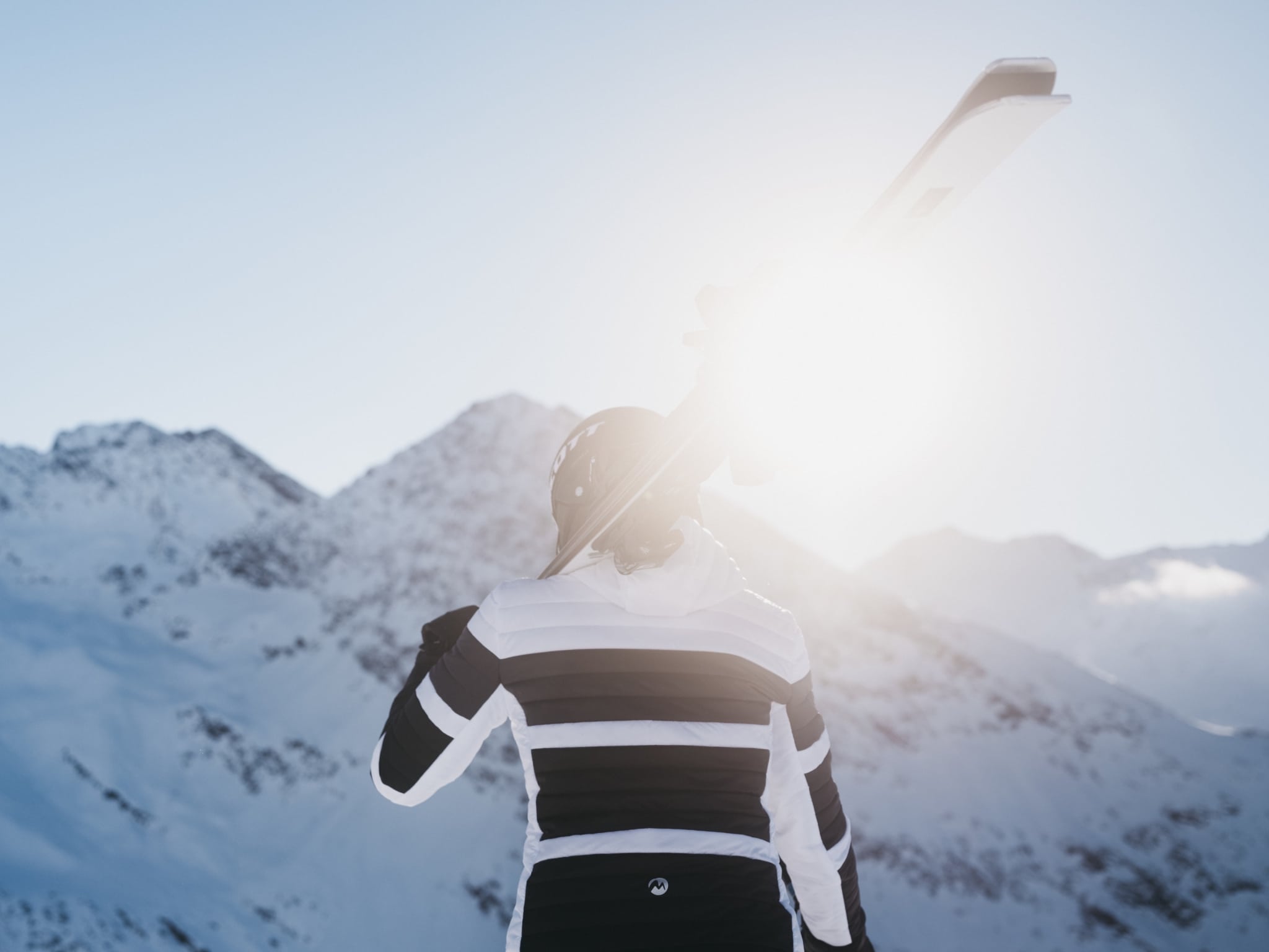 Frau mit Ski im Sonnenschein mit Bergpanorama